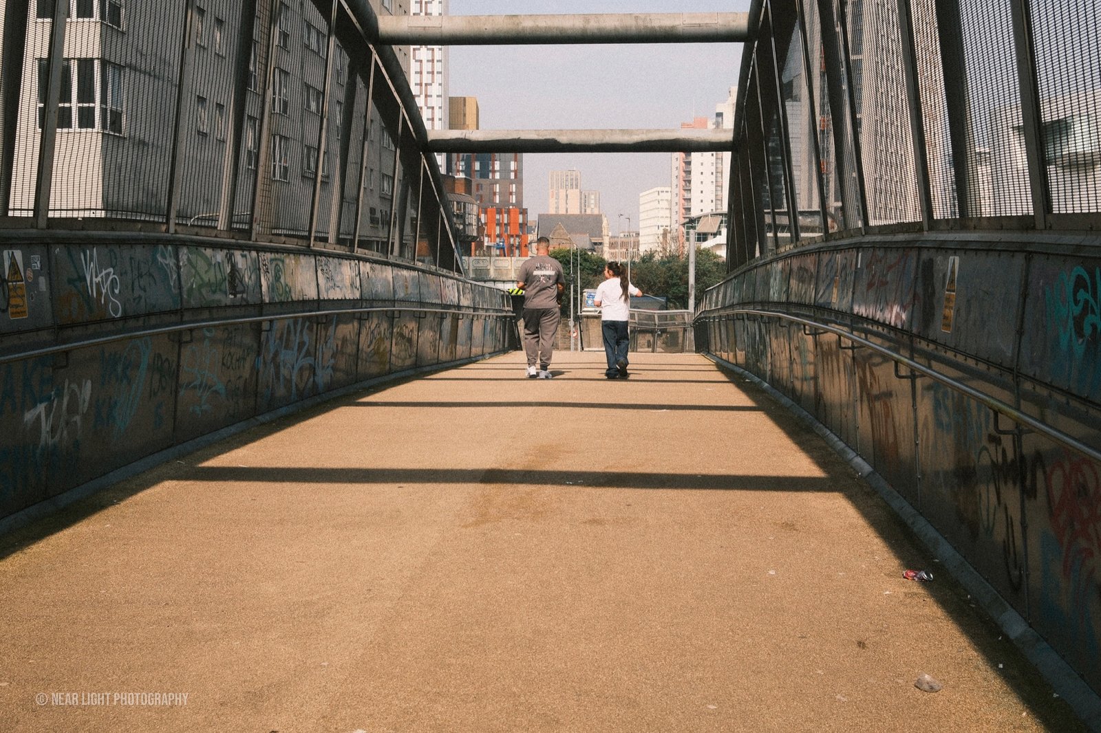 People walking across an urban pedestrian bridge